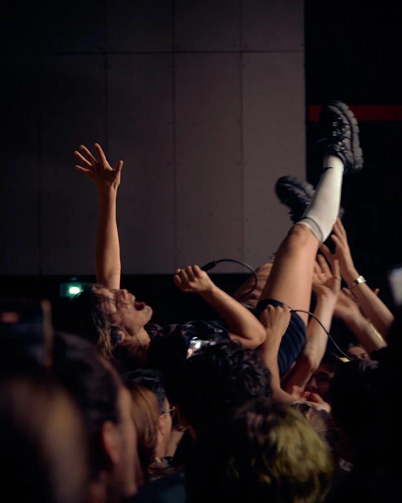 Concert : une personne portée à bout de bras au-dessus du public.